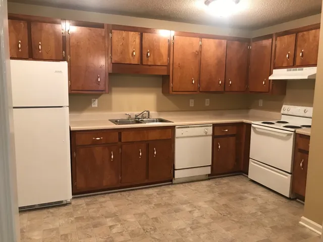 a kitchen with a sink a stove and cabinets