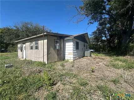 a house with green field in front of it