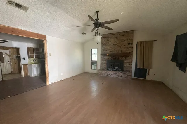 a view of empty room with fireplace and fan