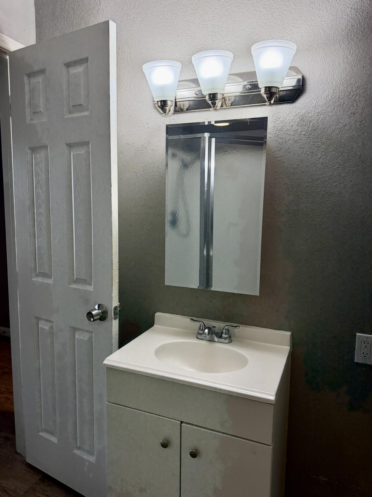 4818 36th Street Lubbock, TX 79414 - Photo 21 of 25 a bathroom with a sink and mirror
