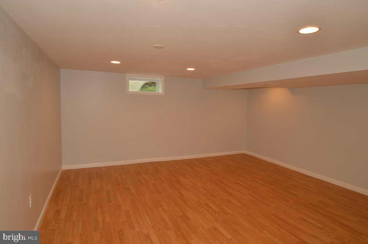 6104 Chanceford Road Baltimore, MD 21228 - Photo 11 of 17 a view of an empty room with wooden floor and a window