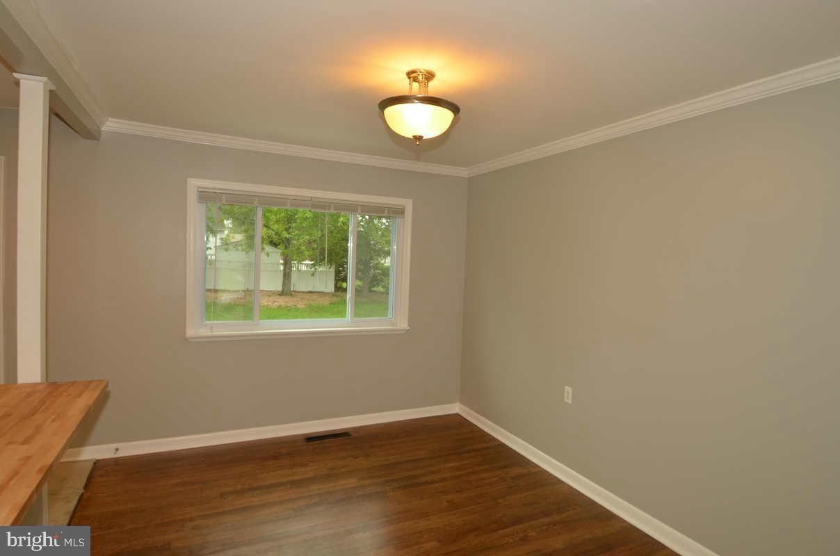 6104 Chanceford Road Baltimore, MD 21228 - Photo 14 of 17 a view of an empty room with wooden floor and a window