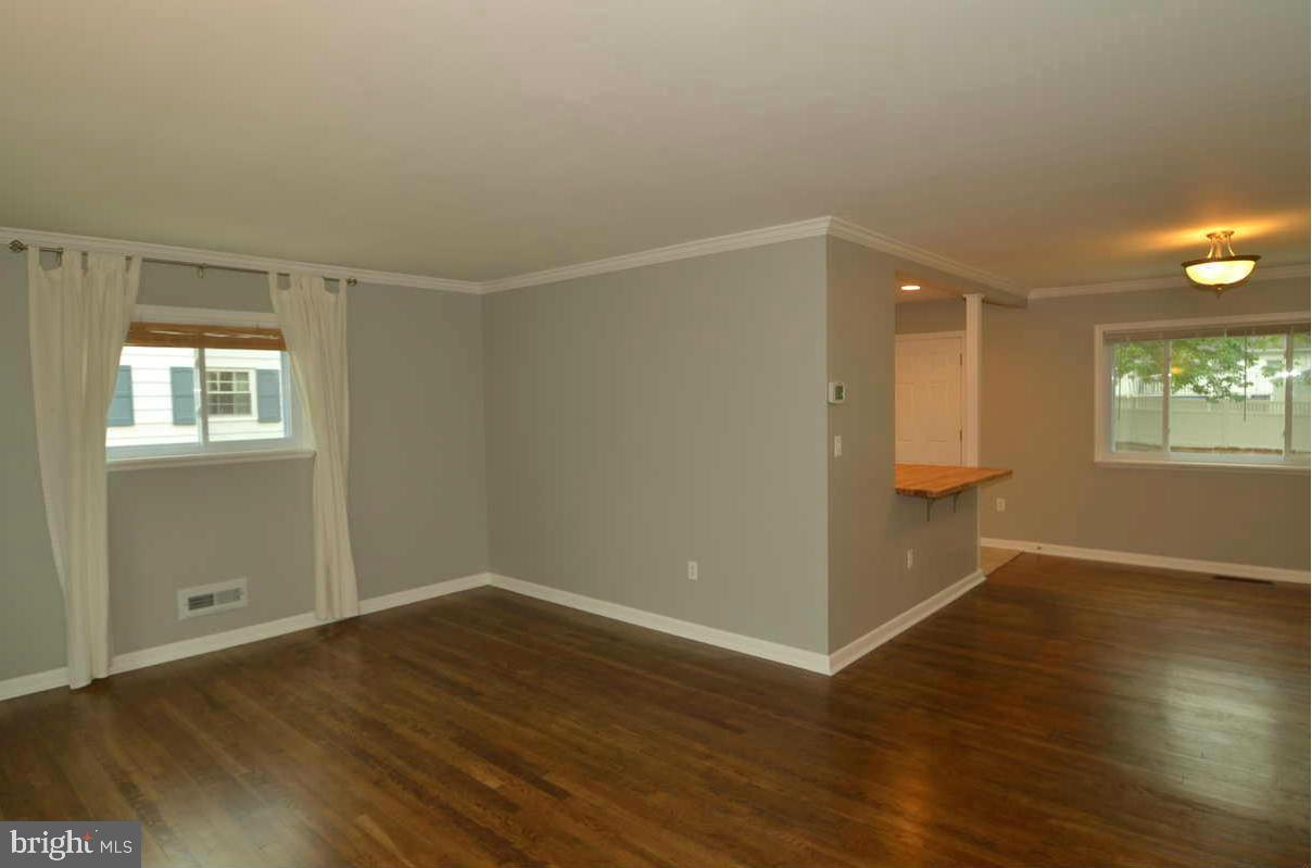 6104 Chanceford Road Baltimore, MD 21228 - Photo 4 of 17 an empty room with wooden floor and windows