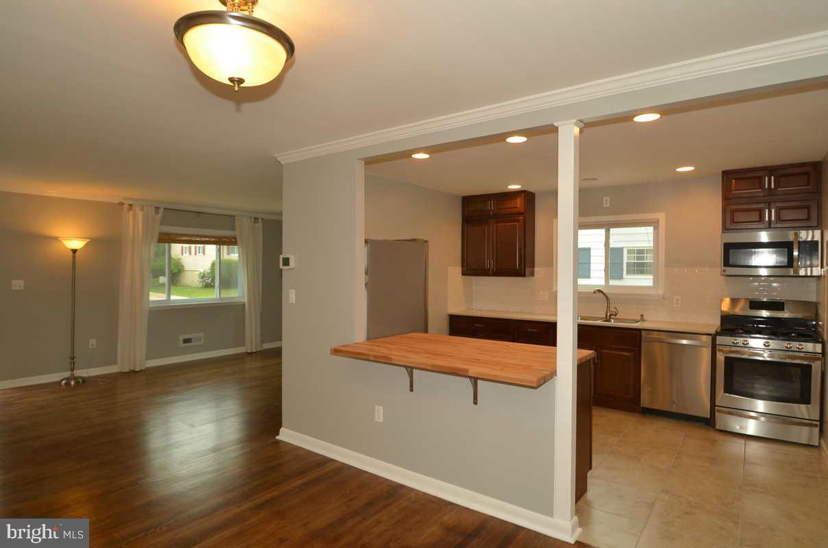 6104 Chanceford Road Baltimore, MD 21228 - Photo 6 of 17 an open kitchen with wooden floor and stainless steel appliances