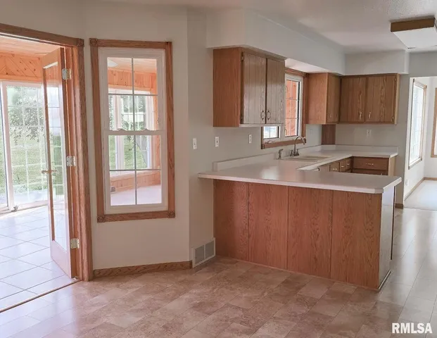 a kitchen with stainless steel appliances granite countertop a sink and a window