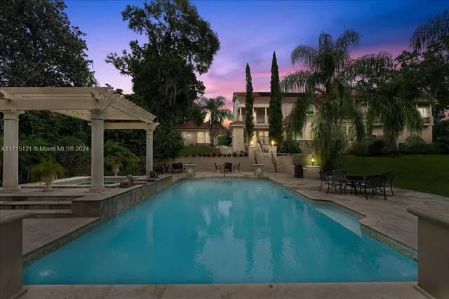 a view of a house with pool and chairs