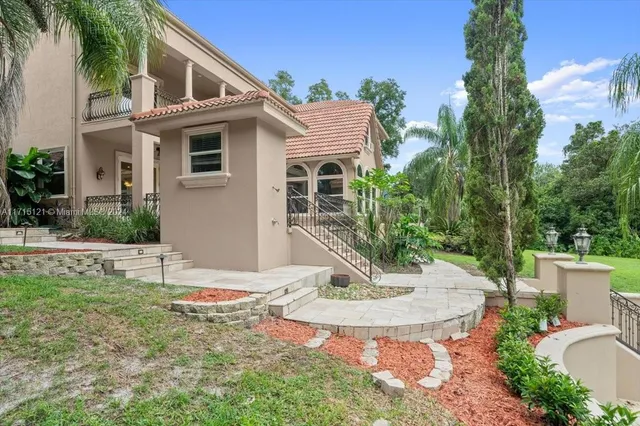 a view of a patio with table and chairs potted plants and palm tree