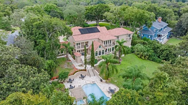 a bathroom with a toilet a sink a mirror a shower a vanity and window