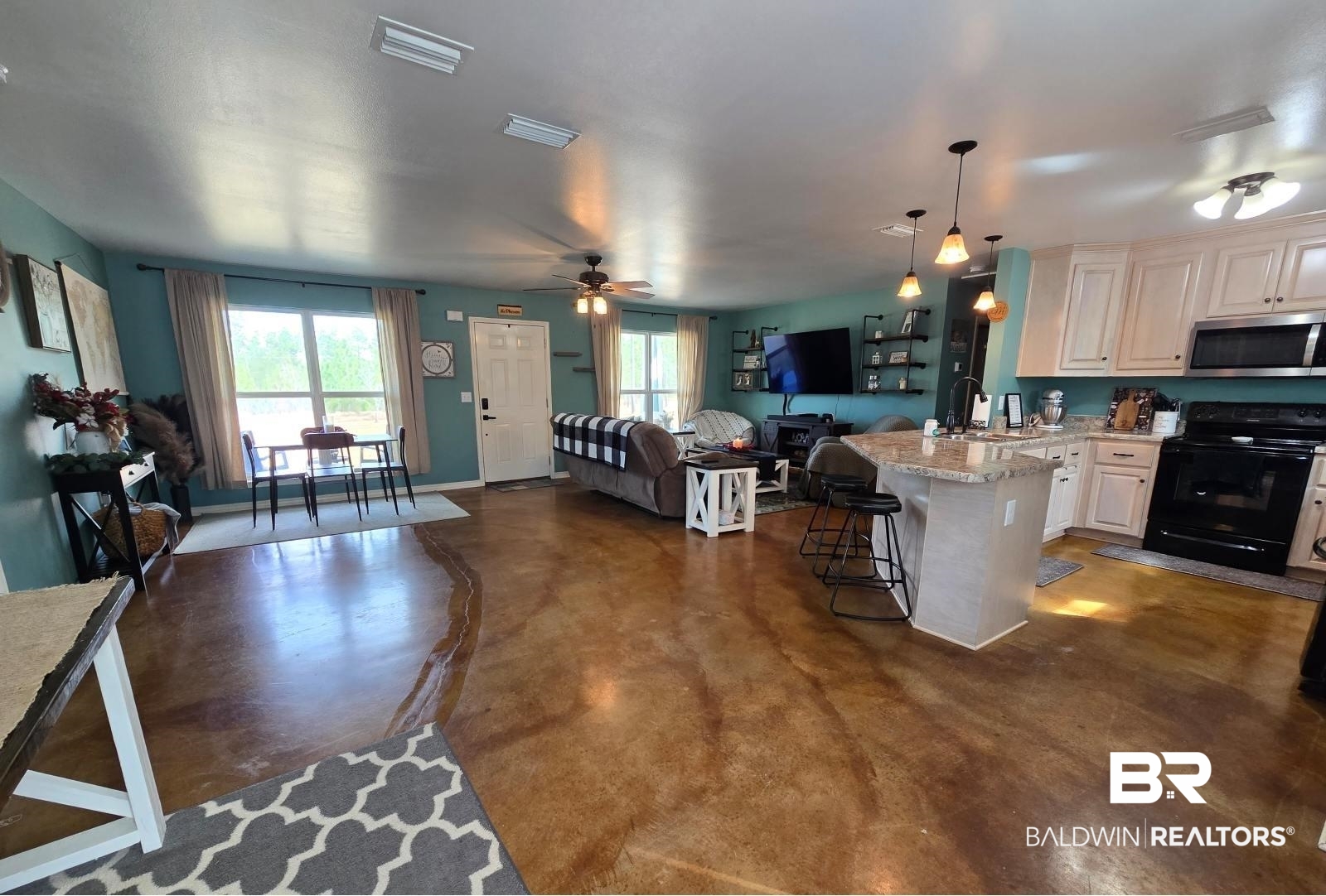 52041 Robert White Road Bay Minette, AL 36507 - Photo 11 of 16 Kitchen with light stone countertops, decorative light fixtures, black electric range oven, ceiling fan, and a breakfast bar