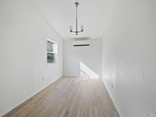 a view of a hallway with wooden floor and a window