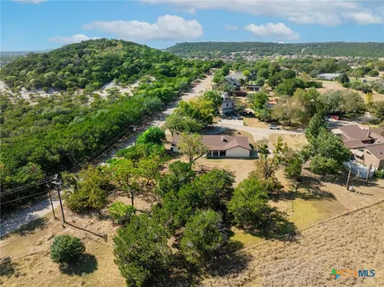 an aerial view of residential houses with outdoor space and trees