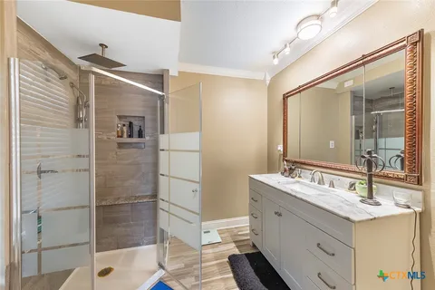 a bathroom with a double vanity sink mirror and shower