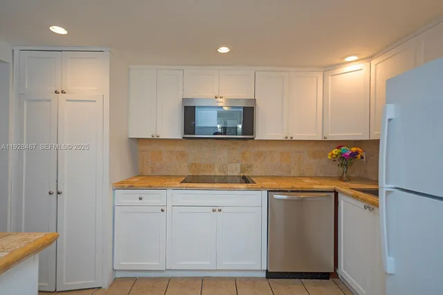 a kitchen with granite countertop white cabinets and white appliances
