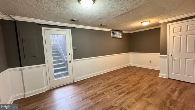 en empty room with wooden floor and white walls