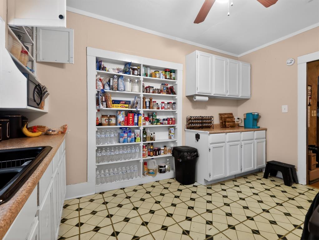 1301 Locust Street Commerce, TX 75428 - Photo 3 of 17 a kitchen with stainless steel appliances a white stove top oven a sink a chimney and a refrigerator