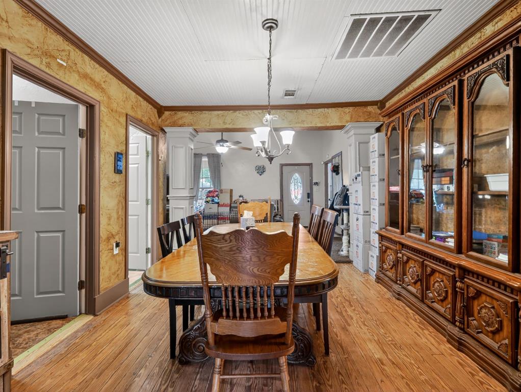 1301 Locust Street Commerce, TX 75428 - Photo 4 of 17 a dining room with furniture a chandelier and wooden floor