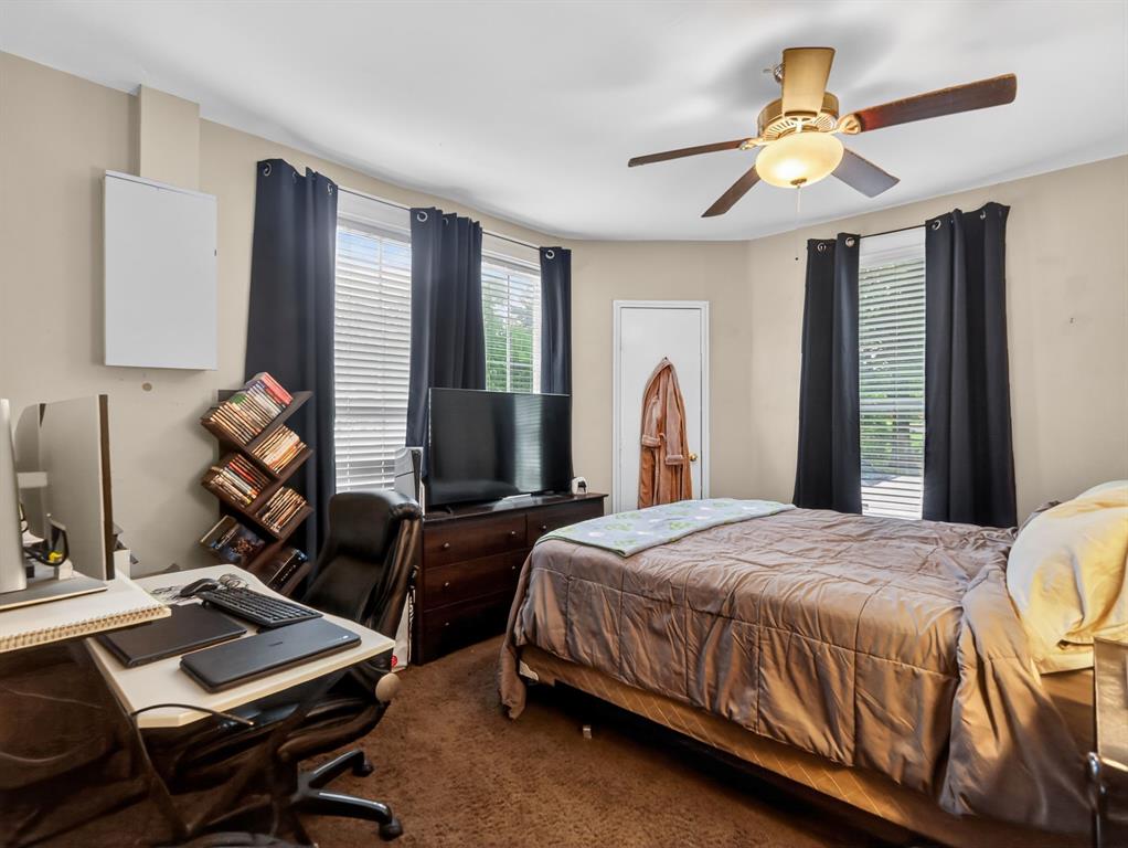1301 Locust Street Commerce, TX 75428 - Photo 7 of 17 a bedroom with a bed gym equipment and a large window