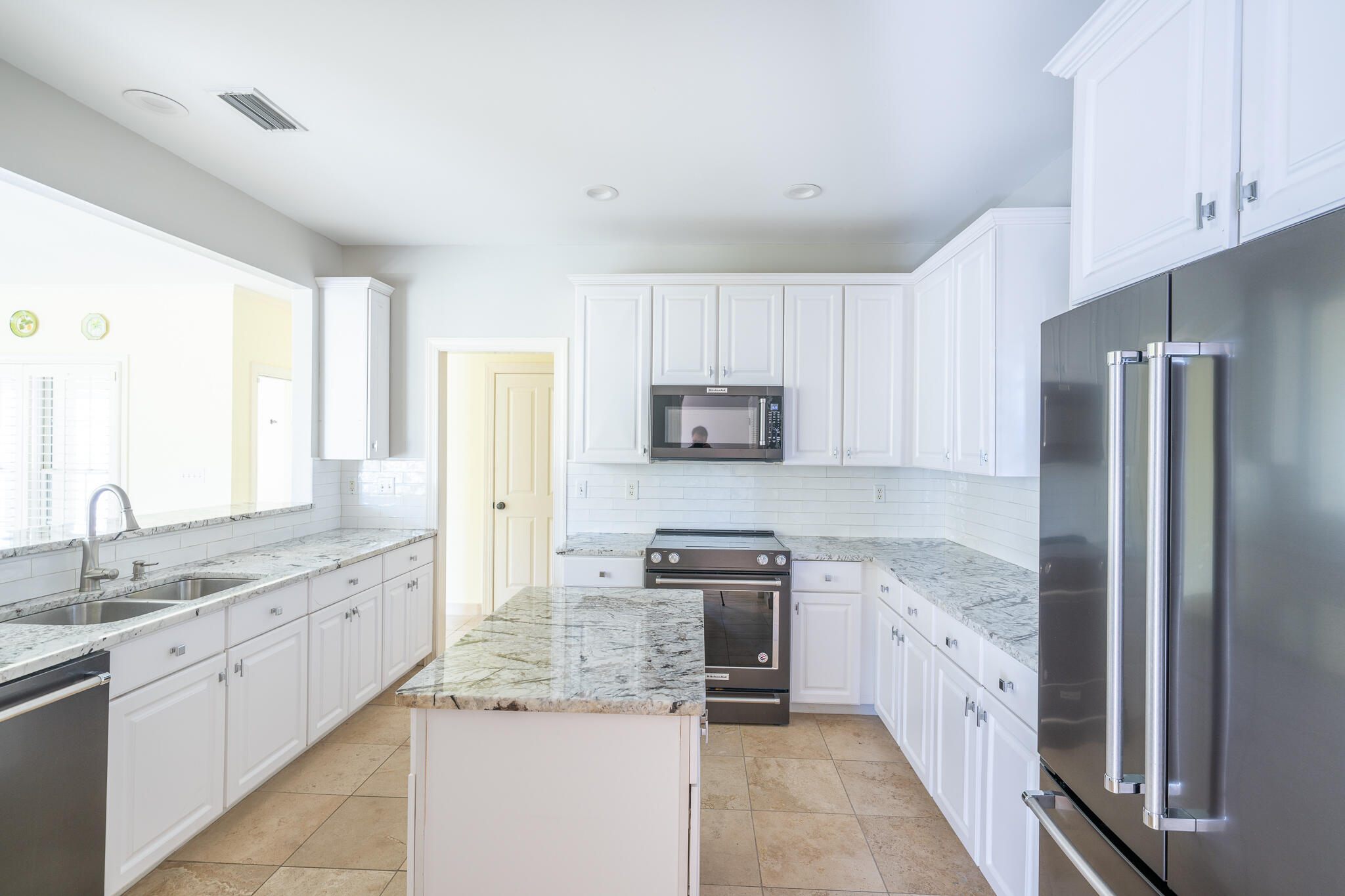 106 Tuscany Drive Destin, FL 32541 - Photo 5 of 41 a kitchen with stainless steel appliances granite countertop a refrigerator sink stove microwave and cabinets
