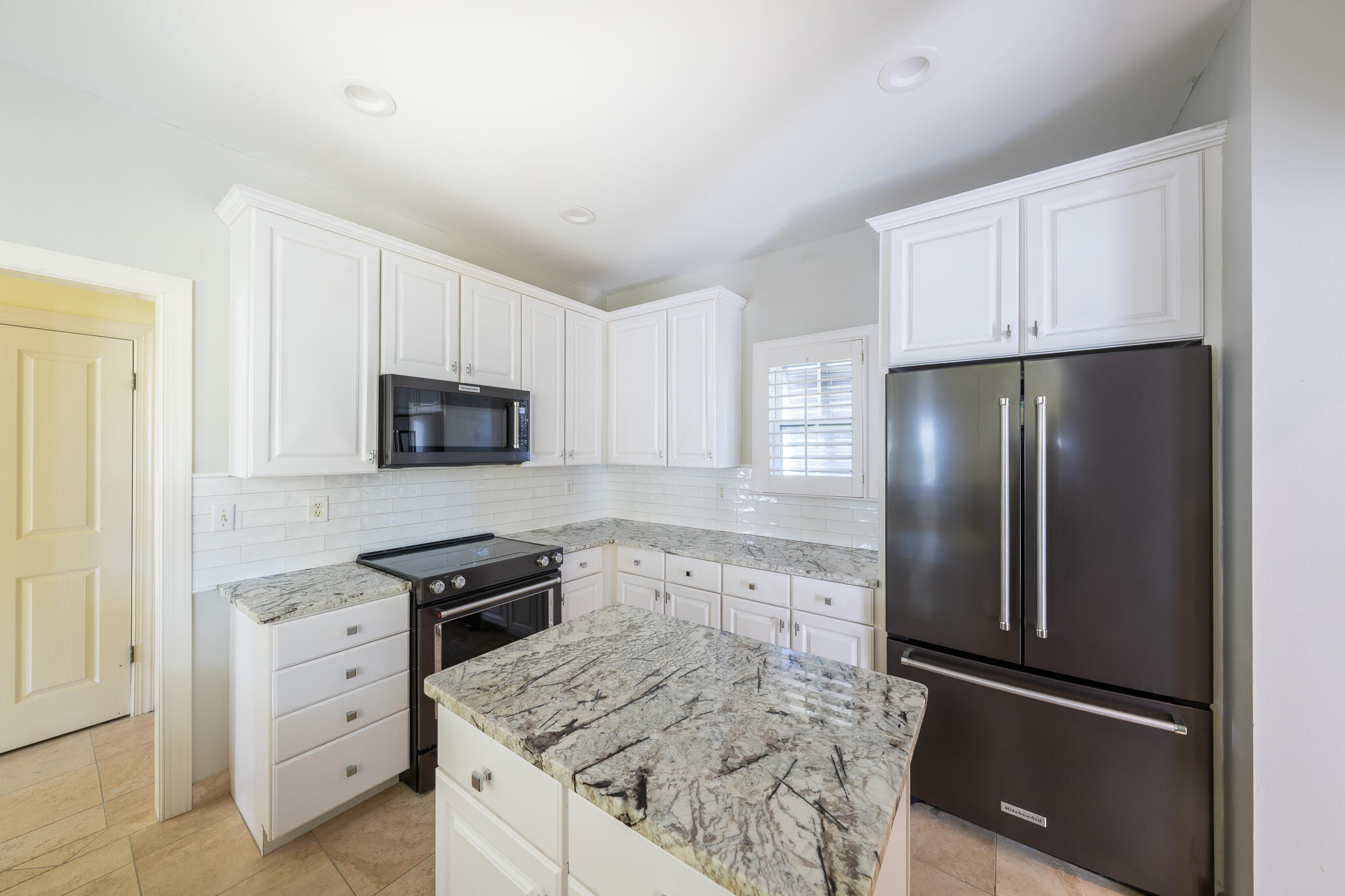 106 Tuscany Drive Destin, FL 32541 - Photo 7 of 41 a kitchen with white cabinets and stainless steel appliances