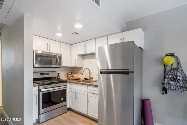 a kitchen with stainless steel appliances a refrigerator a stove a microwave a sink and cabinets