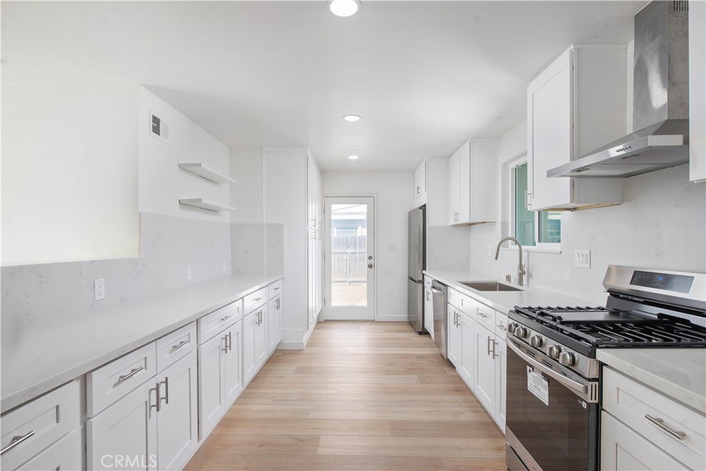 1608 Alviso Street Simi Valley, CA 93065 - Photo 3 of 13 a kitchen with white cabinets stove and sink