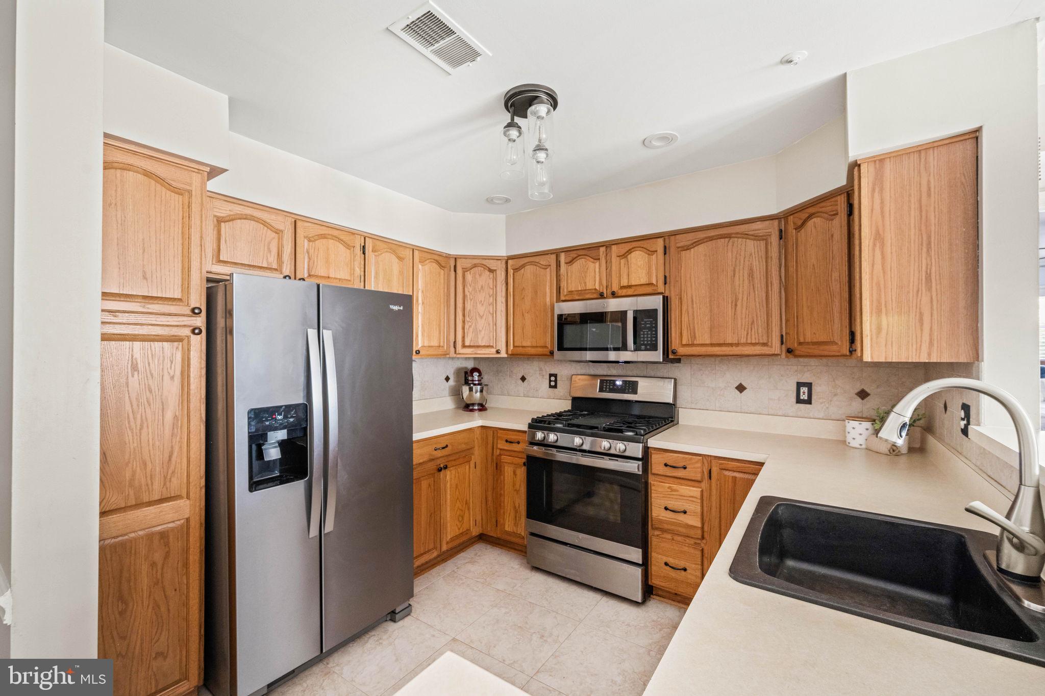 6602 Thackwell Way, Unit C Alexandria, VA 22315 - Photo 16 of 54 a kitchen with stainless steel appliances a refrigerator sink and stove