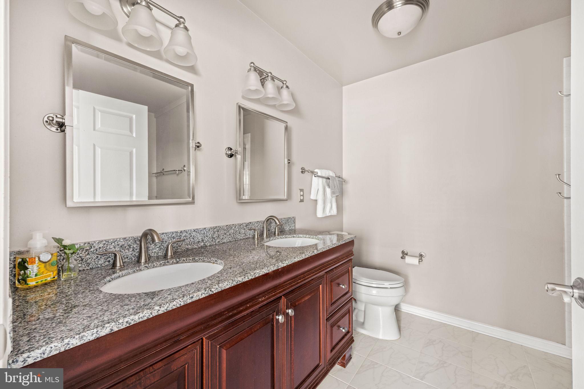6602 Thackwell Way, Unit C Alexandria, VA 22315 - Photo 27 of 54 a bathroom with a granite countertop sink a toilet and a mirror