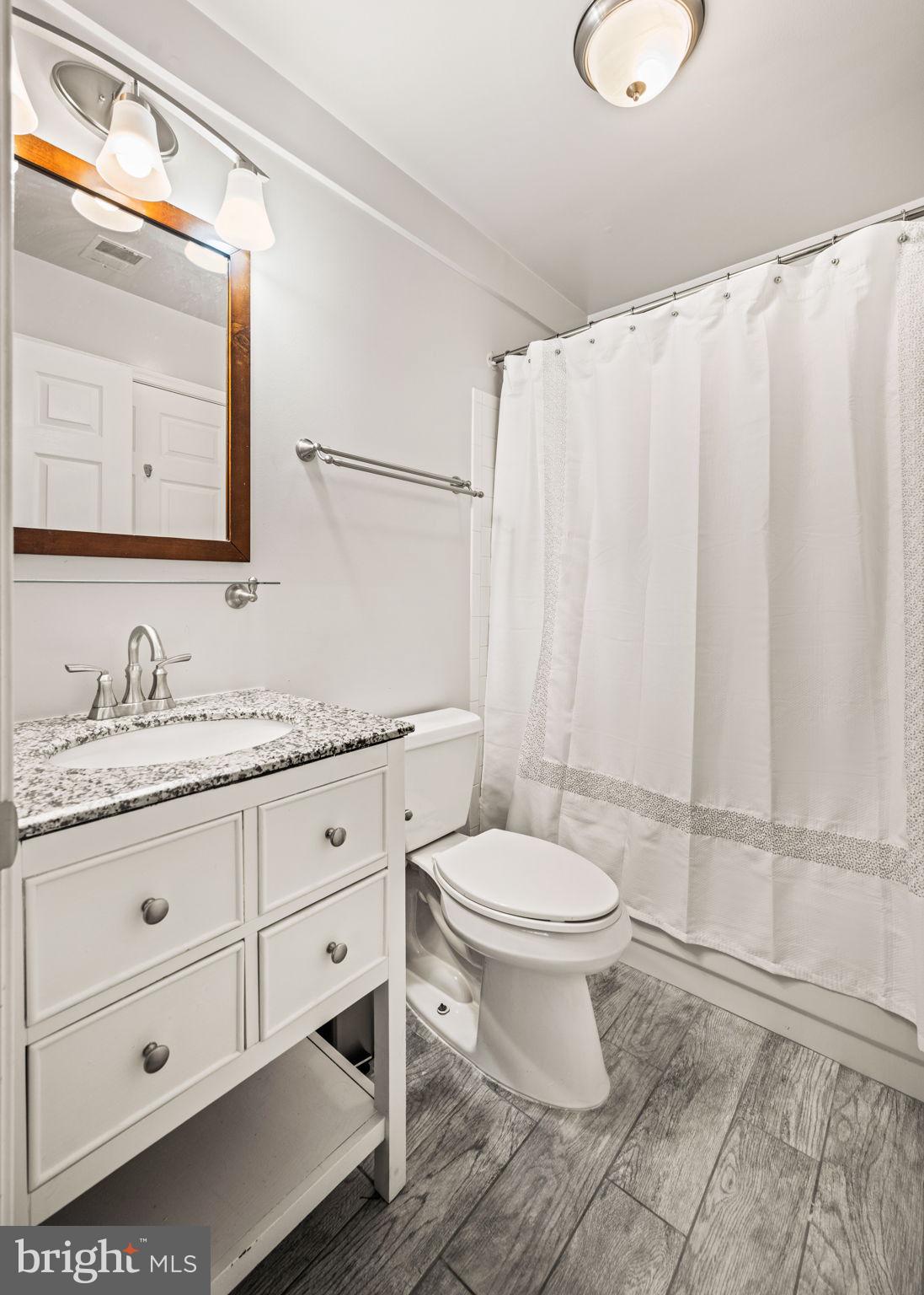 6602 Thackwell Way, Unit C Alexandria, VA 22315 - Photo 33 of 54 a bathroom with a granite countertop sink toilet and mirror