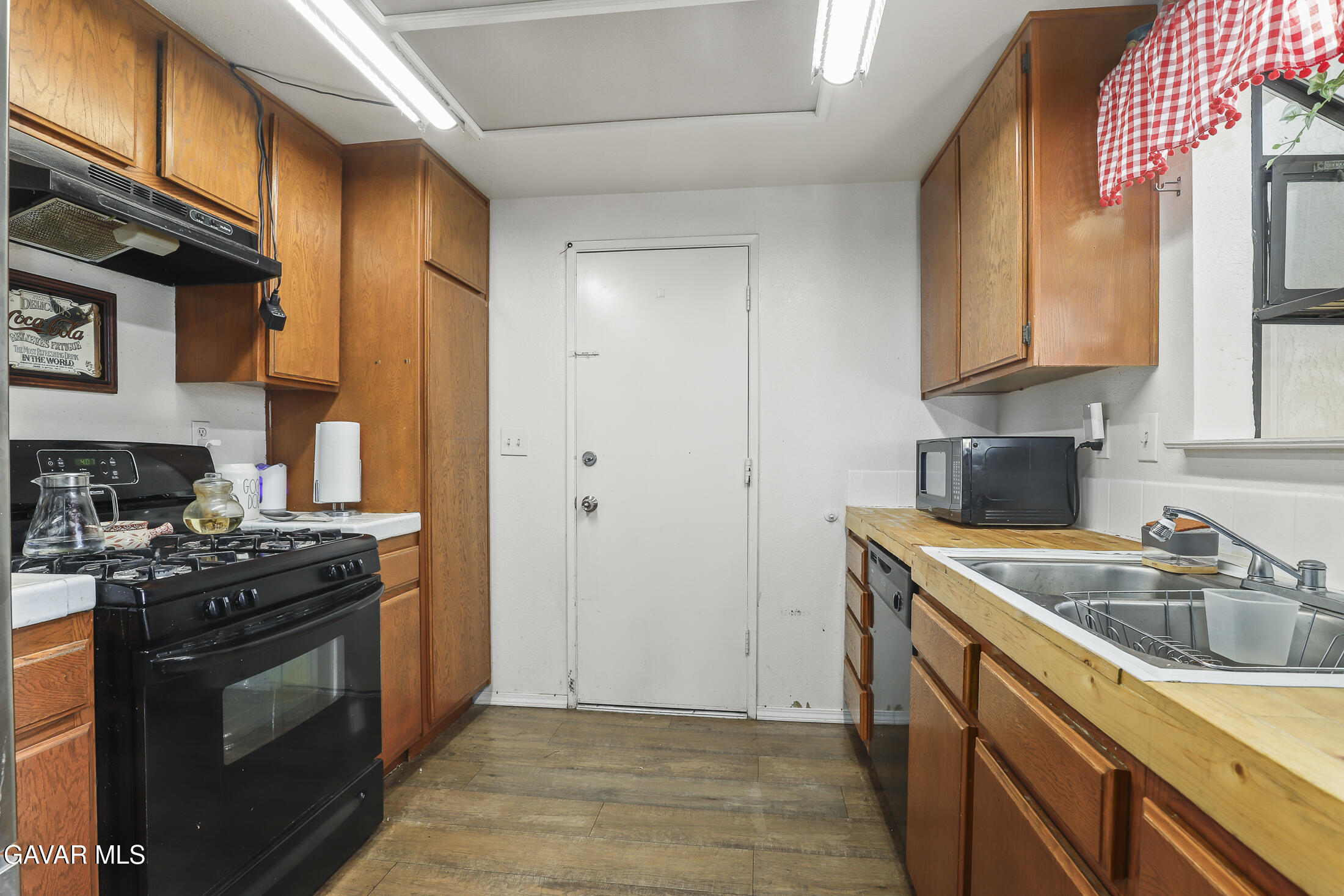 1535 East Ave R 6 Palmdale, CA 93550 - Photo 11 of 23 a kitchen with stainless steel appliances granite countertop a stove a sink and a microwave