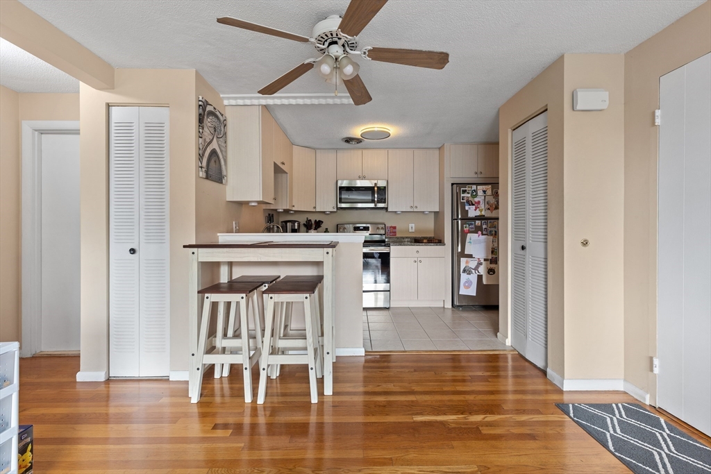 145 Warren Street, Unit 8 Watertown, MA 02472 - Photo 4 of 10 a kitchen with stainless steel appliances kitchen island granite countertop a refrigerator and a stove top oven