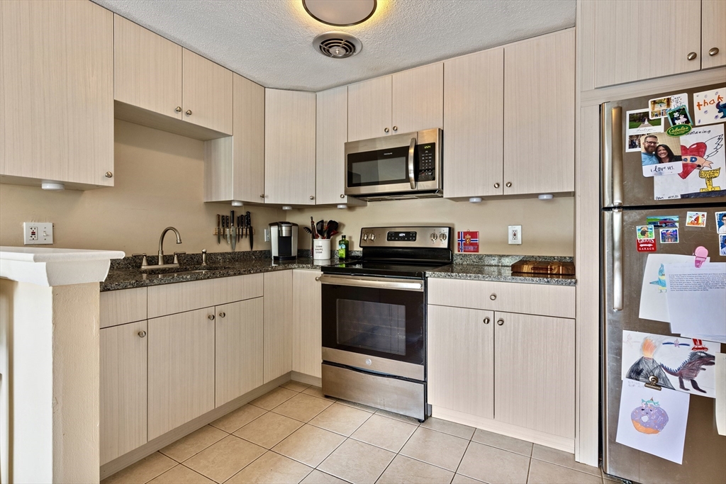 145 Warren Street, Unit 8 Watertown, MA 02472 - Photo 5 of 10 a kitchen with stainless steel appliances granite countertop a sink and a microwave