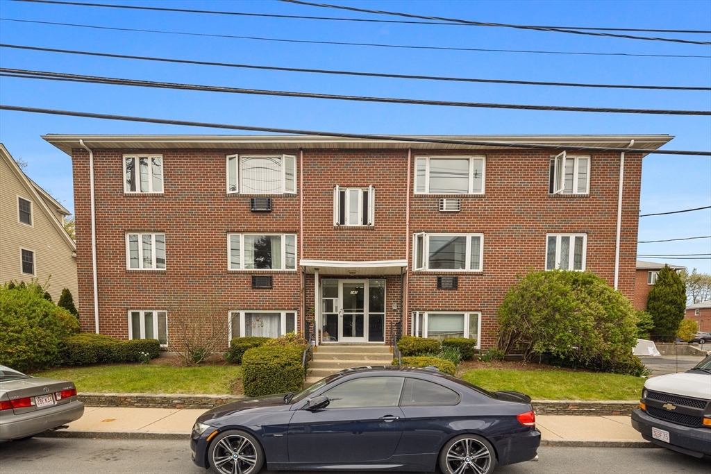 145 Warren Street, Unit 8 Watertown, MA 02472 - Photo 10 of 10 a front view of a house with a garden and parking space