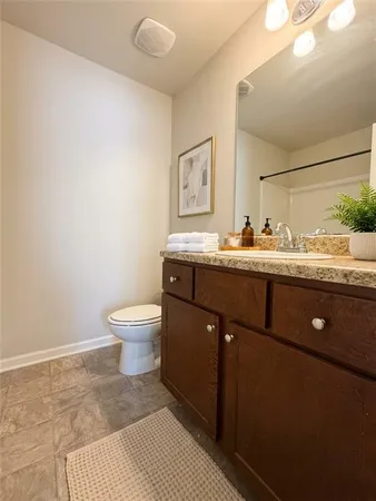 a bathroom with a sink a toilet and mirror