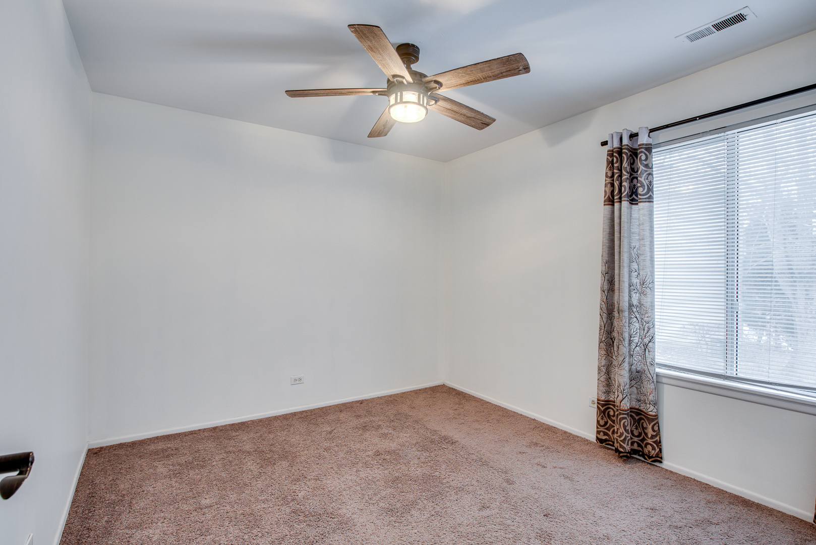 340 Springlake Lane, Unit D Aurora, IL 60504 - Photo 12 of 15 an empty room with windows and fan