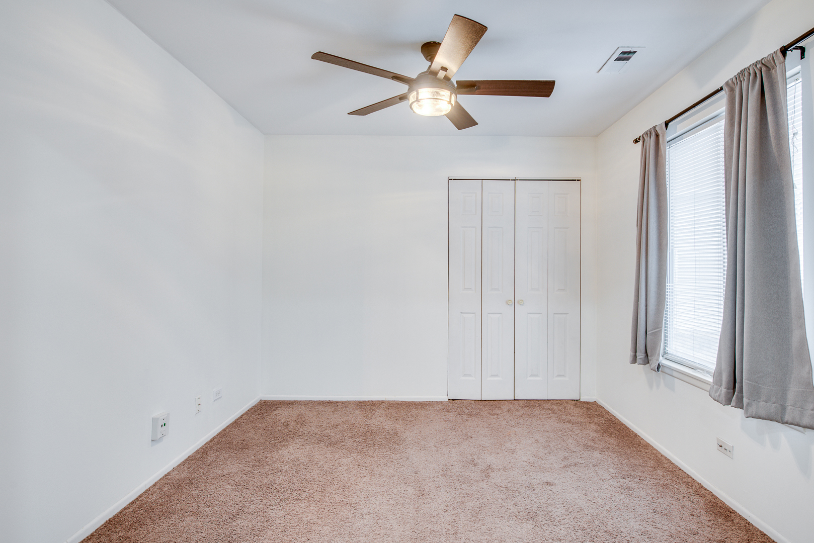 340 Springlake Lane, Unit D Aurora, IL 60504 - Photo 10 of 15 an empty room with a ceiling fan and window