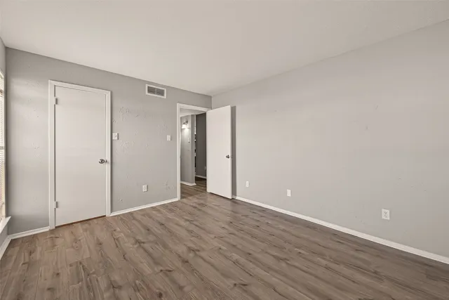 a view of an empty room with wooden floor