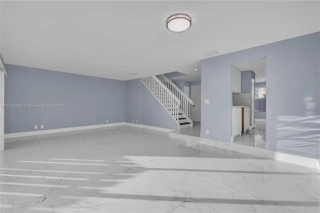 a view of a livingroom with wooden floor and a large window