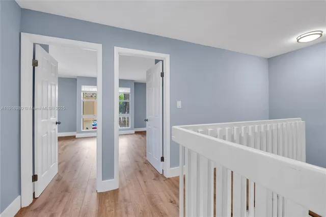 a view of a hallway with wooden floor and closet
