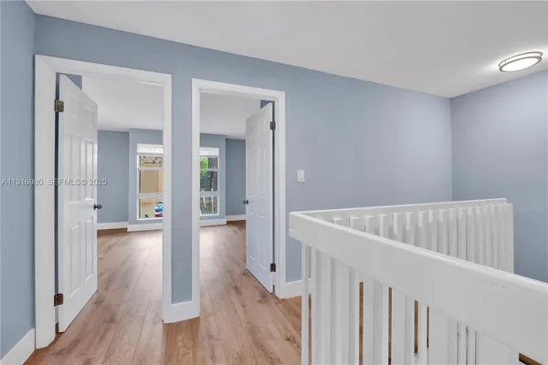 a view of a hallway with wooden floor and closet