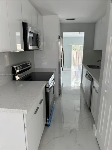 a kitchen with a sink a stove and a refrigerator