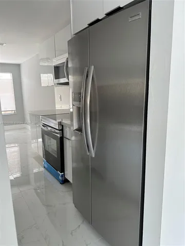 a metallic refrigerator freezer sitting in a kitchen