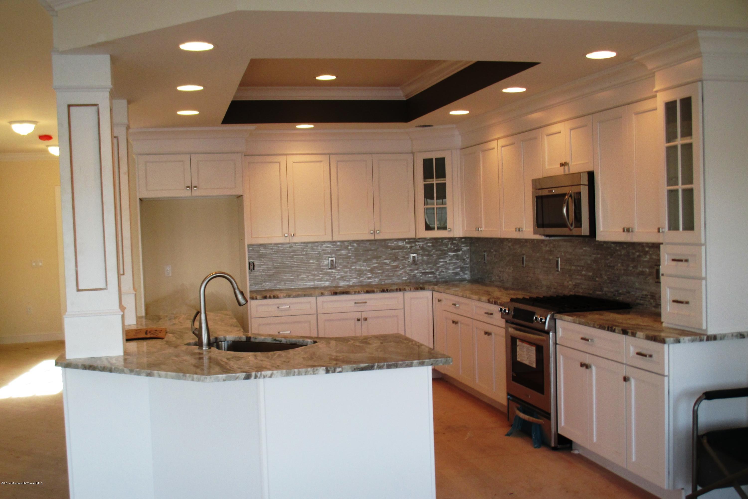 632 Harbor Road Brick, NJ 08724 - Photo 3 of 9 a kitchen with kitchen island granite countertop a sink and a stove top oven with wooden floor