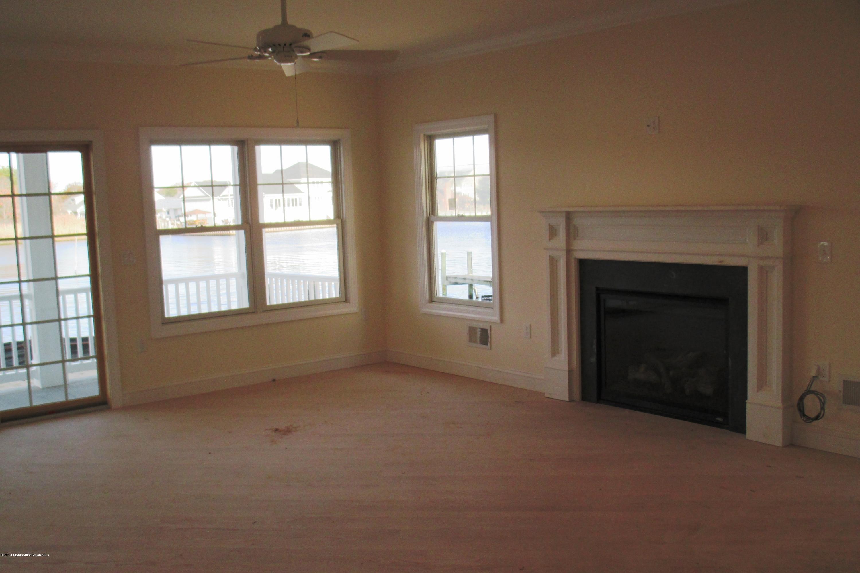 632 Harbor Road Brick, NJ 08724 - Photo 5 of 9 an empty room with windows and fireplace