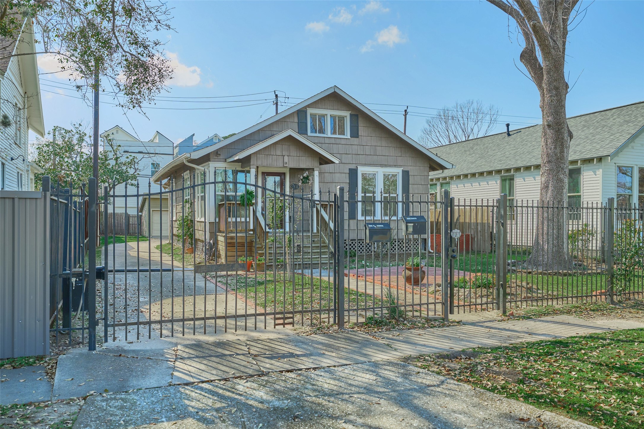1111 Rutland Street Houston, TX 77008 - Photo 4 of 43 a view of a brick house in front of a yard with plants and large trees