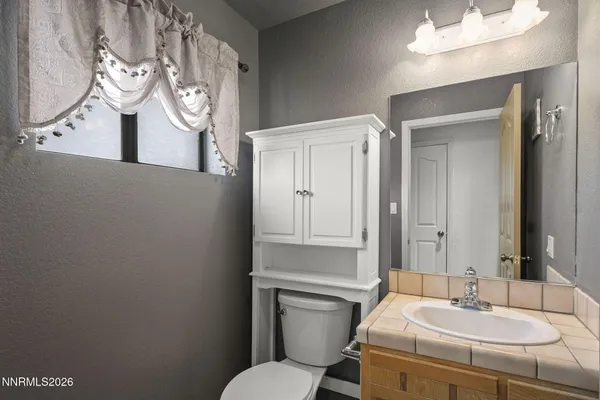 a bathroom with a sink mirror vanity and toilet