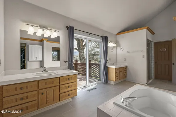 a spacious bathroom with a granite countertop sink mirror and bathtub