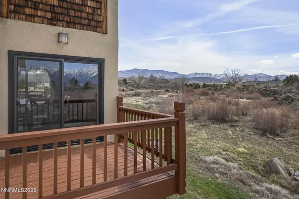 a view of a balcony with a floor to ceiling window and wooden fence