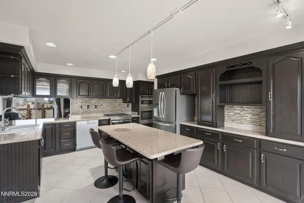 a kitchen with granite countertop a sink and stainless steel appliances