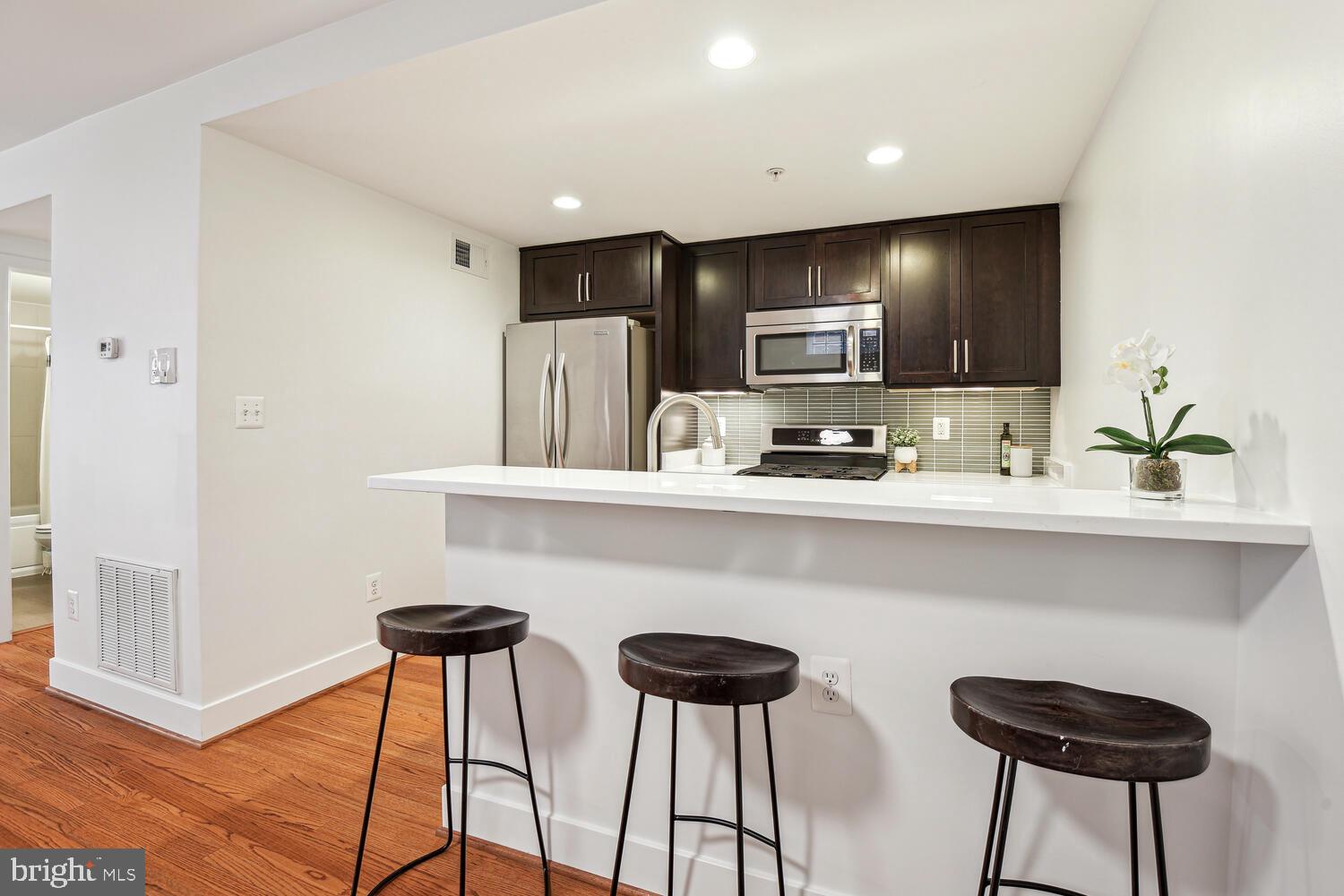 1317 Shepherd Street Northwest, Unit A Washington, DC 20011 - Photo 12 of 17 a kitchen with stainless steel appliances a table and chairs in it