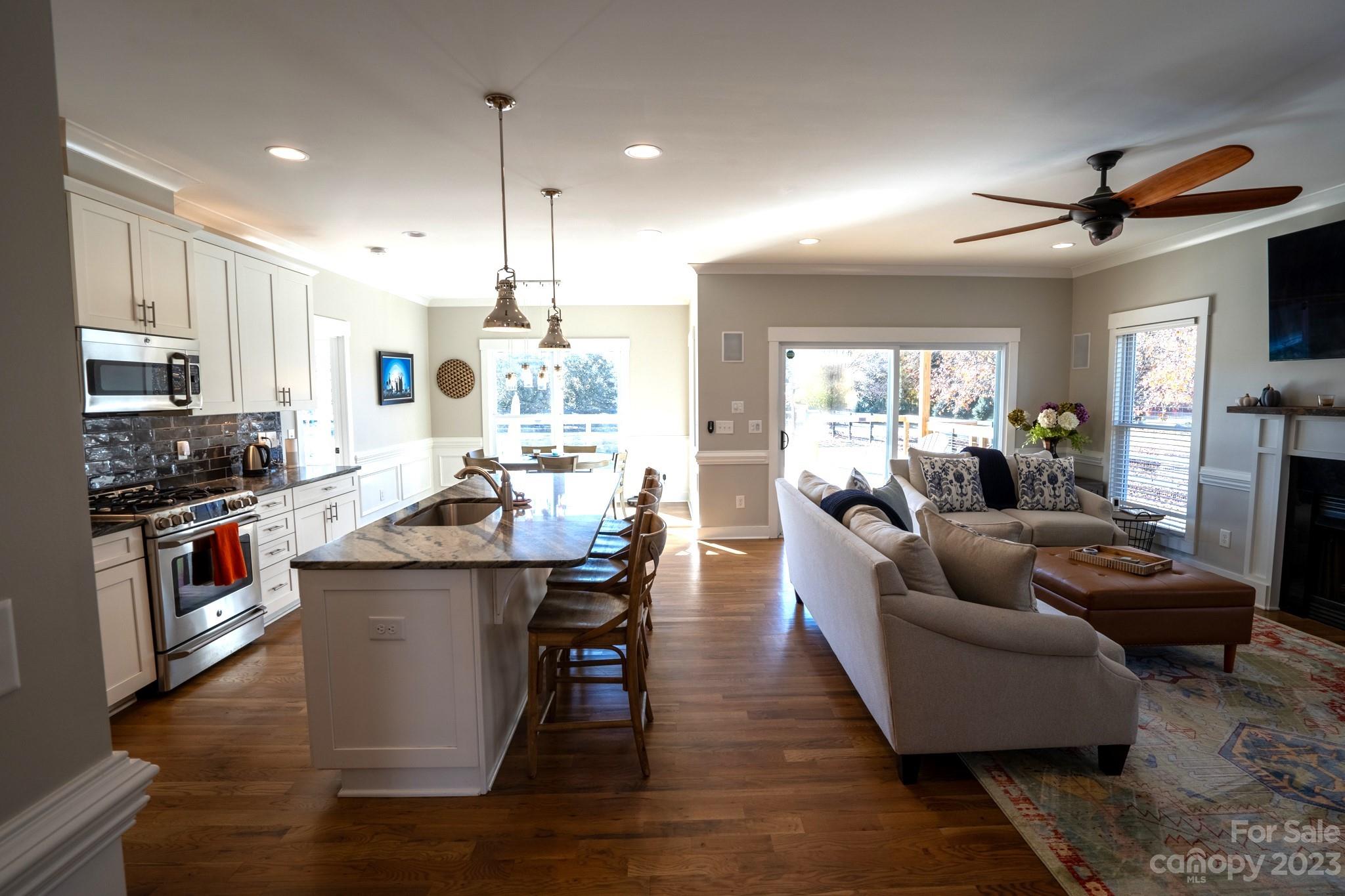 1411 Mary Ellen Drive Fort Mill, SC 29708 - Photo 15 of 37 a living room with stainless steel appliances kitchen island granite countertop furniture a rug a stove and a kitchen view